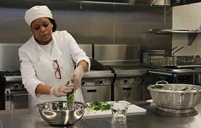 Hospitality student cooks in the kitchen.